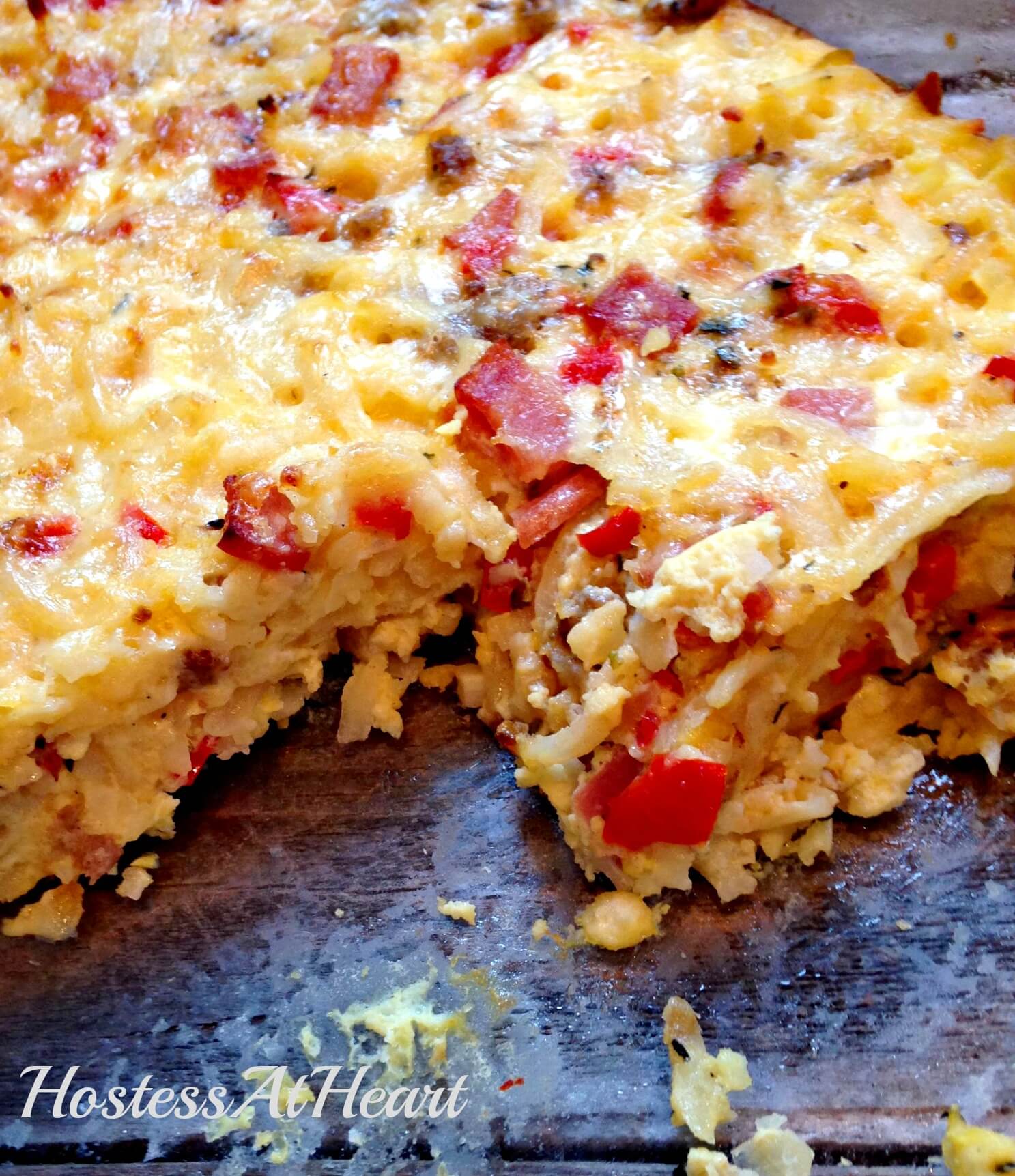 A pan of Sausage, Hashbrowns, and Egg Casserole with a piece missing.