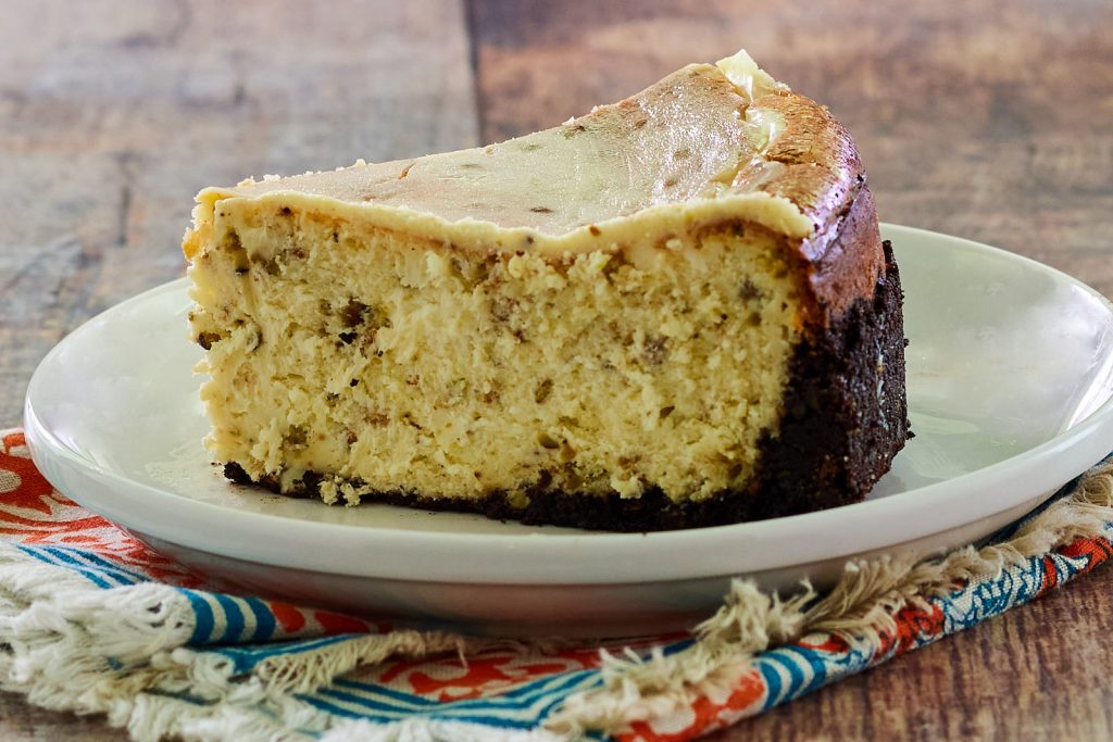 Close-up of a single slice of White Chocolate Cheesecake with Pistachios.