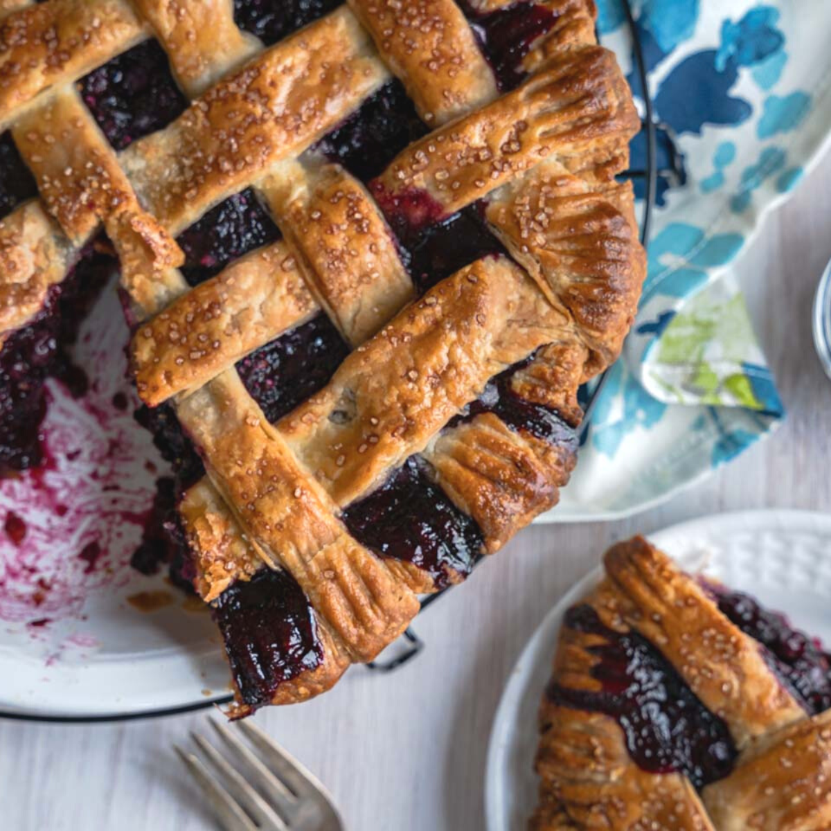 Top down view of a blue berry pie and slice