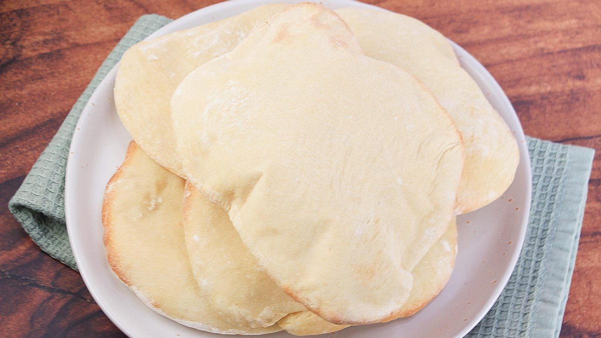 Recipe for Pita Bread Top down view of a plate holding homemade baked pita bread.