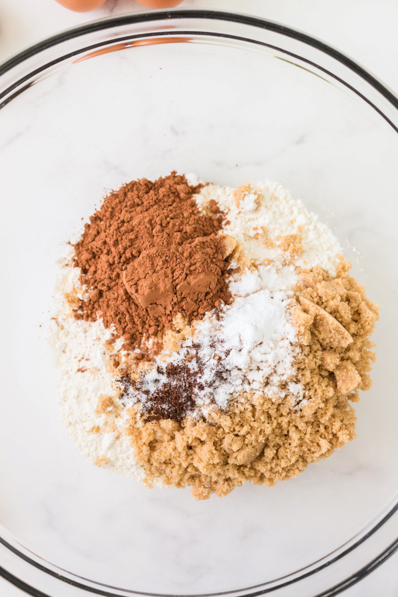 A mixing bowl filled with dry chocolate doughnut ingredients before mixing. Hostess At Heart